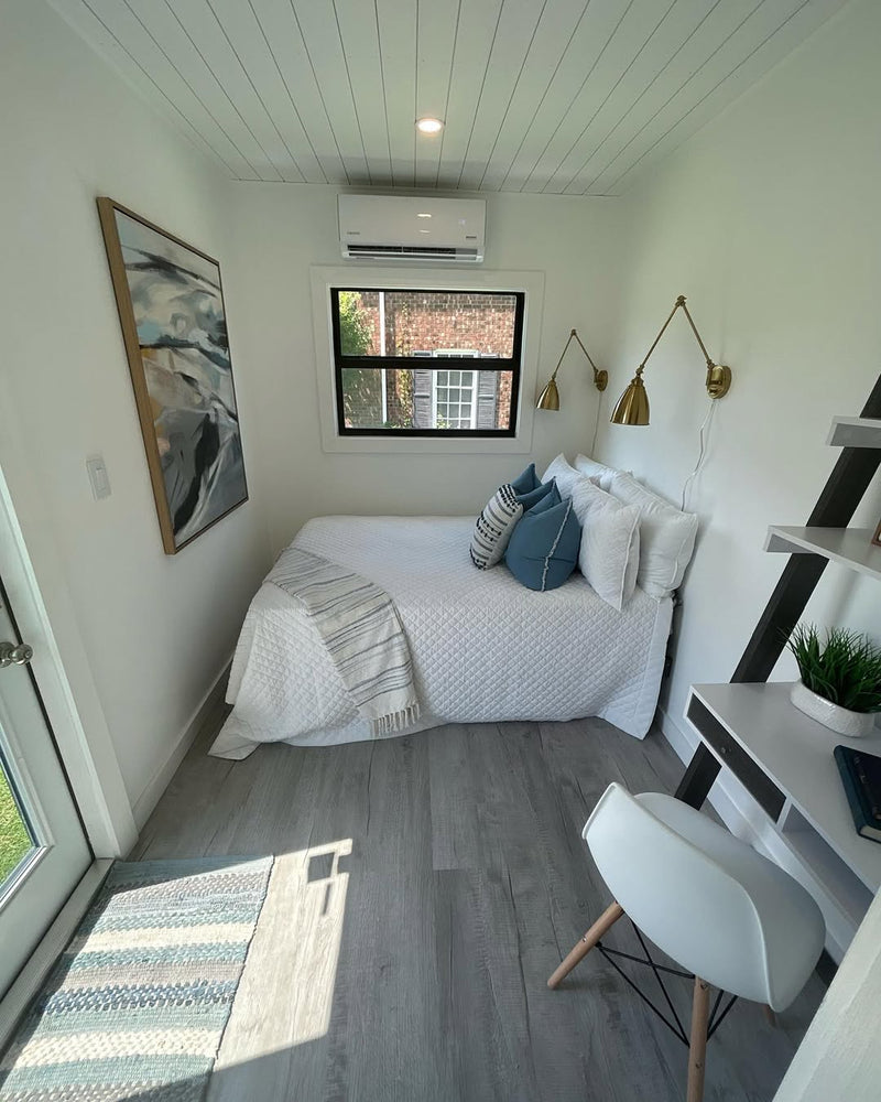 Small bedroom with a bed, desk, and window.